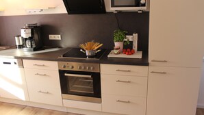 A modern kitchen with a built-in oven, a microwave, and a coffee maker. - High quality, modern with infrared sauna. Awarded 4 stars by the DTV. (Lierschied)