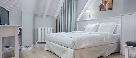 A bedroom with a bed, a desk, a radiator, and a painting on the wall.