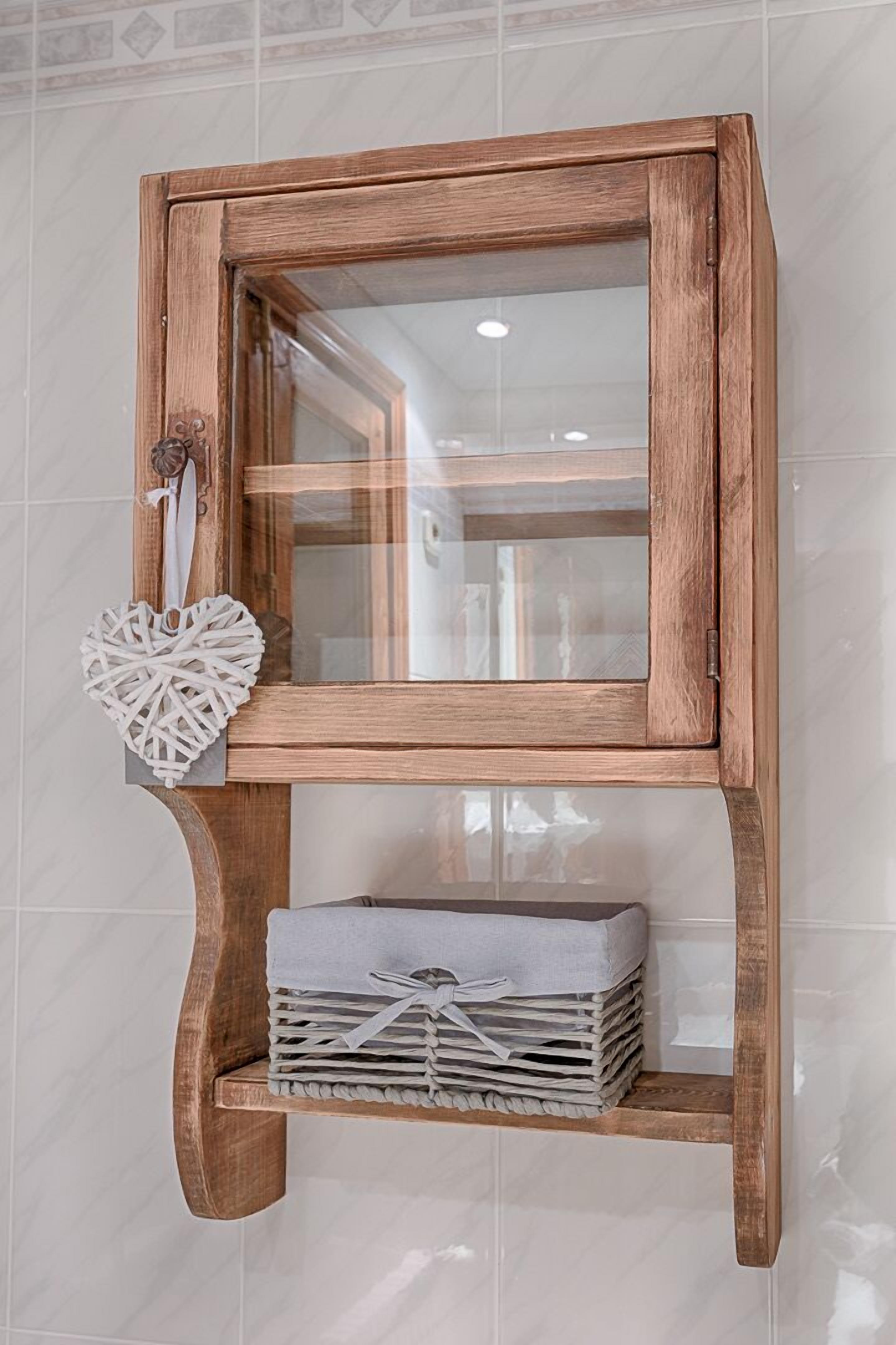 A wooden cabinet with a glass door and a heart-shaped decoration hanging on it.