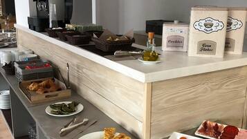 A buffet setup with various food items and a coffee machine.