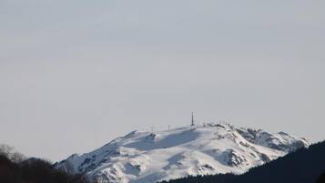 A snow-covered mountain with a ski lift and a transmission tower.