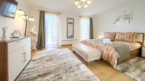 A well-lit bedroom with a bed, bedside tables, a dresser, a mirror, and a television. - Villa NATHALIE with private pool, jacuzzi and outdoor sauna (Linardici)