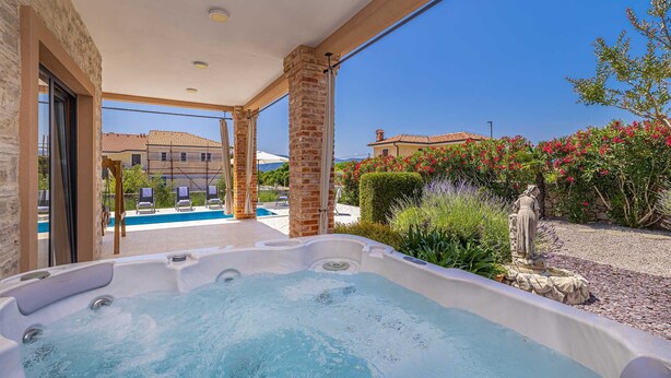 A hot tub area with a pool, outdoor seating, and a view of a villa and garden. - Villa NATHALIE with private pool, jacuzzi and outdoor sauna (Linardici)