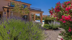 A house with a pool, surrounded by lavender and pink flowers, and a clear blue sky. - Villa NATHALIE with private pool, jacuzzi and outdoor sauna (Linardici)