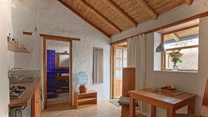 A kitchen with wooden cabinets, a water dispenser, and a window with a view. - Studio Mariposa with a fantastic garden in the historical Quito (Quito)