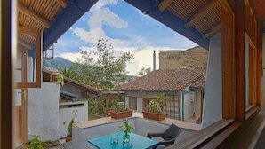 A patio with a table and chairs, surrounded by potted plants and a stone pathway. - Studio Mariposa with a fantastic garden in the historical Quito (Quito)