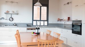 Eine moderne Küche mit weißen Schränken, einem Holzespeisetisch und einem Fenster über der Spüle.