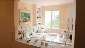 A cozy living room with a sofa, a coffee table, and a painting on the wall. - Private Family Villa with Heated Pool near Cannes (Spéracèdes)