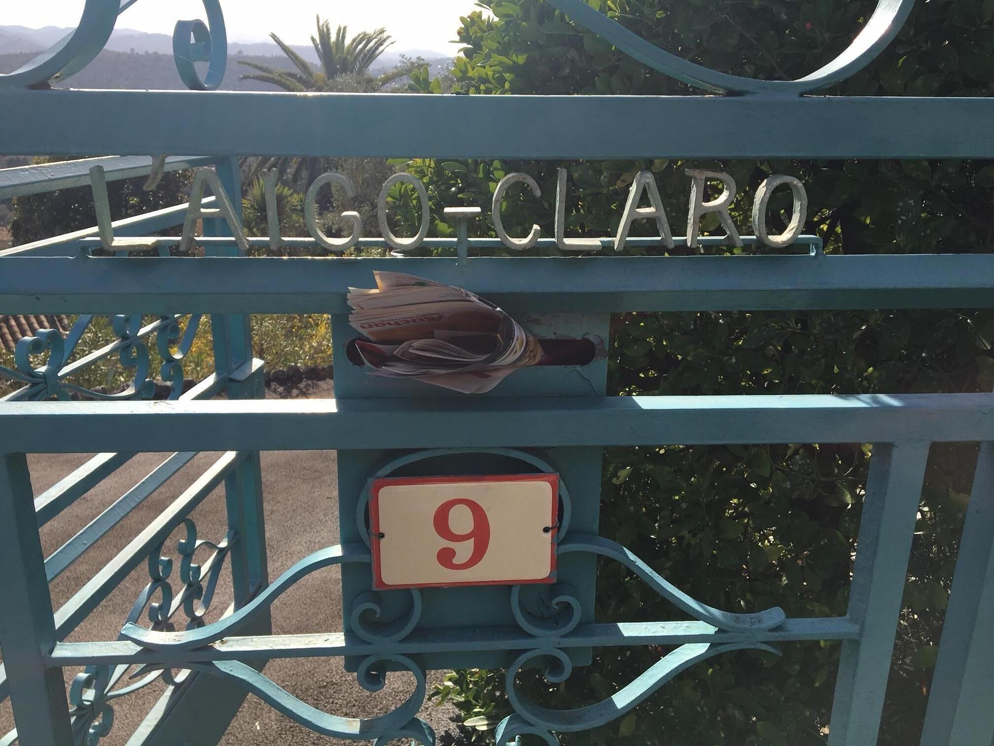 Una reja metálica con el nombre "FARCO-CLARO" y un cartel con el número "9".
