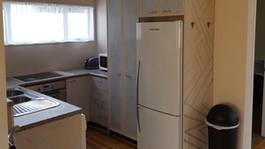 A compact kitchen with a refrigerator, microwave, toaster, and sink.