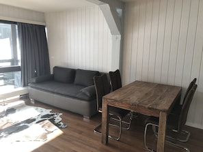 Relax in this stylish living space with a sofa, dining table, and chairs.