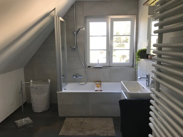 Baignoire, séchoir à cheveux, pantoufles, serviettes fournies