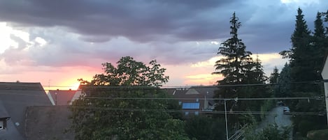 A residential area with houses, trees, and a cloudy sky.