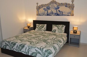 Een slaapkamer met een bed, twee nachtkastjes en een decoratief object boven het bed.
