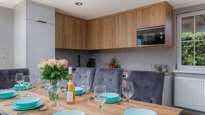 A modern kitchen with grey upholstered chairs, a wooden cabinet, and a built-in oven.