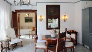 Un comedor con mesa y sillas de madera, una araña y un cuadro en la pared.
