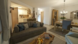 Una sala de estar moderna con un sofá, una mesa de centro y una zona de comedor.
