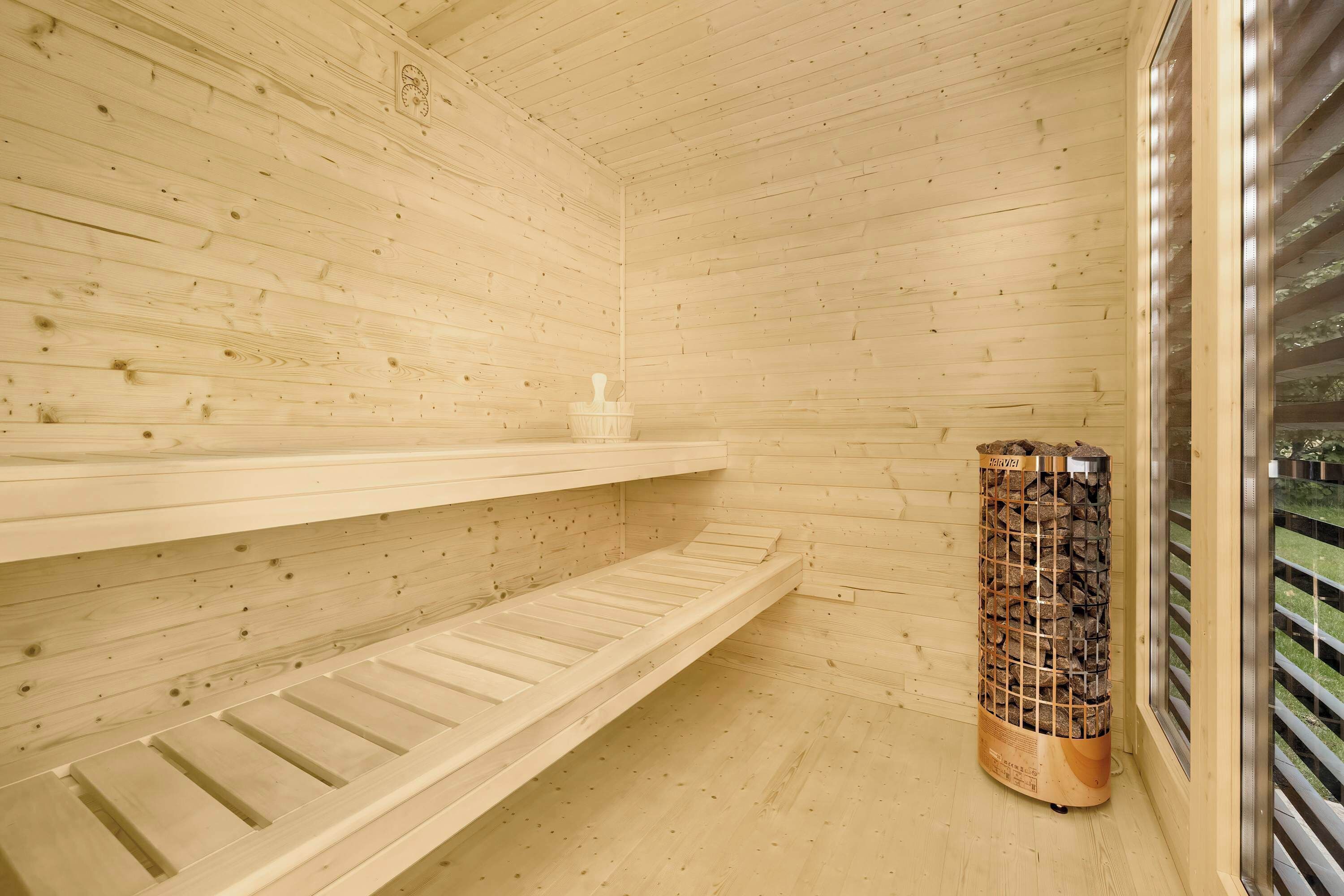 The light wood and modern heater give the sauna an atmosphere of cozy luxury.
