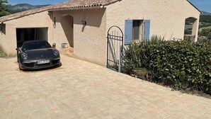 A house with a paved driveway, a parked car, and a gate. - Detached vacation home in a quiet location (Puimoisson)