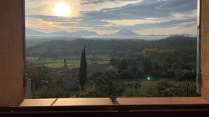 A view from a window overlooking a landscape with mountains, fields, and a prominent church spire. - Detached vacation home in a quiet location (Puimoisson)
