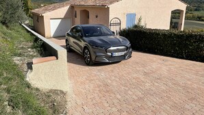 A modern house with a car parked in the driveway, a garage, and a view of mountains in the background. - Detached vacation home in a quiet location (Puimoisson)