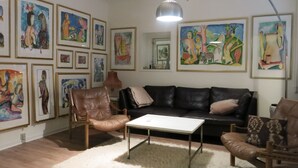A living room with a sofa, chairs, a coffee table, and various framed artworks on the walls. - City Apartment in Frederiksberg with 2 bedrooms sleeps 4 (Frederiksberg)