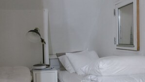 A hotel room with two beds, a bedside table with a lamp, and a mirror on the wall. - City Apartment in Frederiksberg with 2 bedrooms sleeps 4 (Frederiksberg)