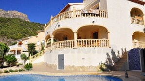 A multi-story building with balconies, a swimming pool, and a mountainous backdrop. - Modern apartment: electricity, washing machine WIFI, bed linen, towels INCL. 4 p (Calpe)