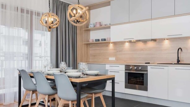 Eine moderne Küche mit weißen Schränken, einer Holz Arbeitsplatte und einem eingebauten Backofen.