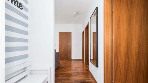 Ein Flur mit Holzboden, einer weißen Bank und einer Tür am Ende.