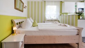 A neatly arranged bedroom with a bed, bedside table, and a window with curtains.