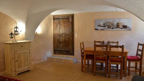 Un comedor con mesa y sillas de madera, un armario de madera y una puerta de aspecto rústico.