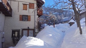 Un edificio cubierto de nieve con contraventanas de madera y un balcón.
