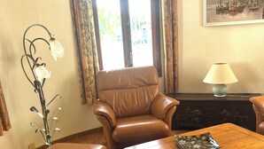 A living room with a brown leather sofa, a wooden coffee table, and a lamp.