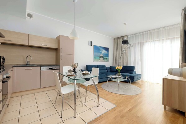 A modern apartment with a kitchen, dining area, and living room.