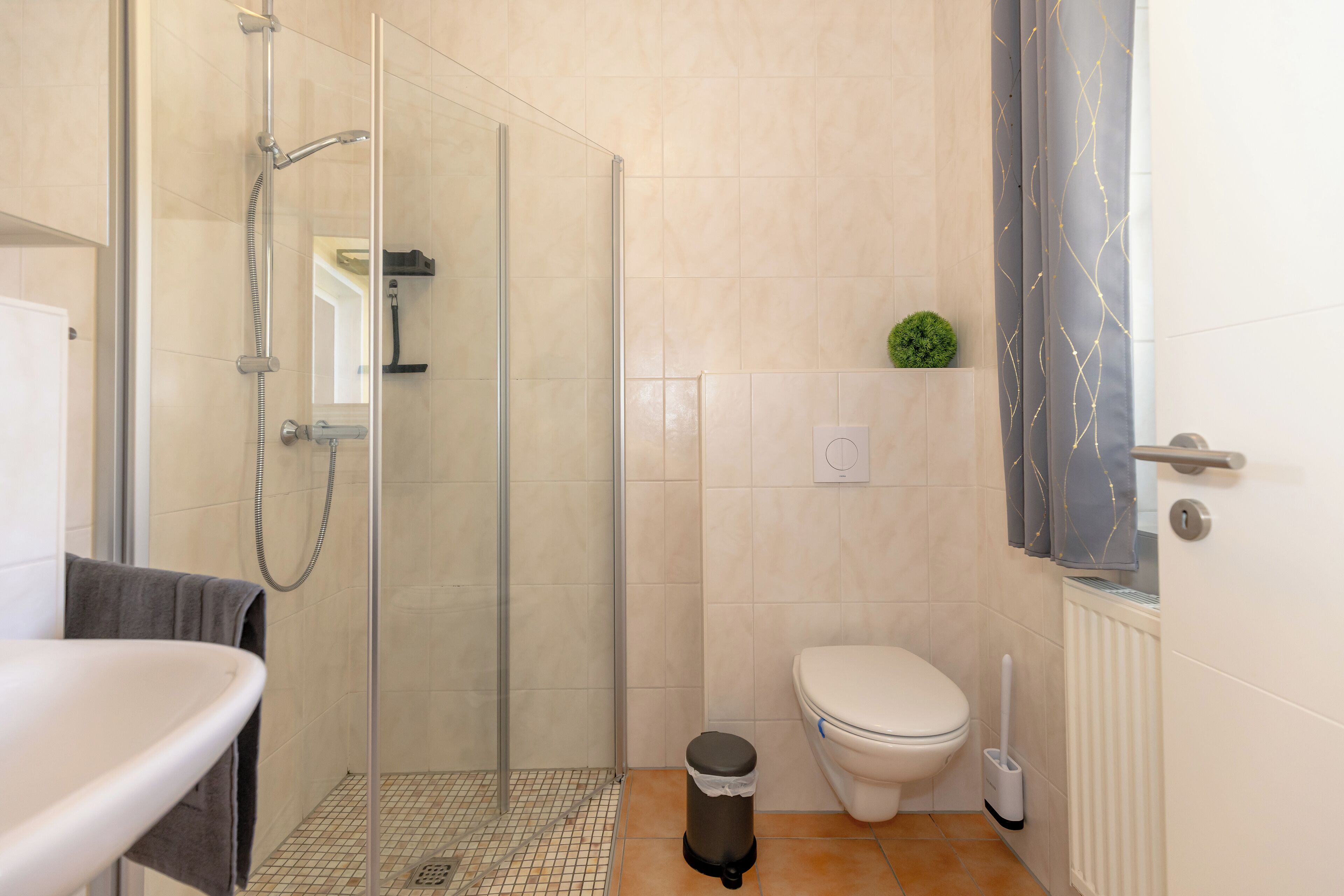Un baño moderno con cabina de ducha de vidrio, inodoro y lavabo.