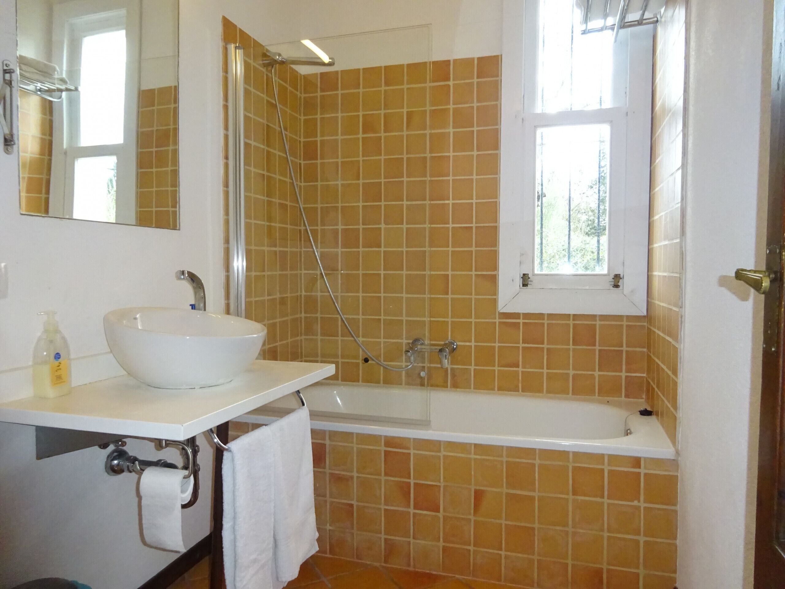 Un baño con lavamanos blanco, bañera y ducha.