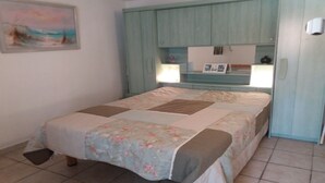 Ein Schlafzimmer mit Bett, Nachttisch, Kommode und einem Bild an der Wand.