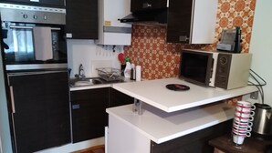 A compact kitchen with a built-in oven, microwave, and a small countertop.
