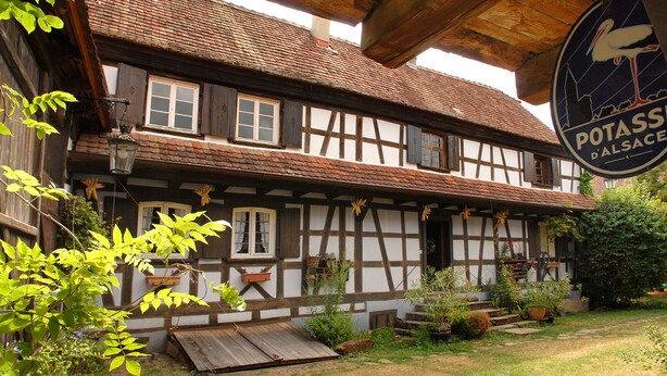 Una casa tradicional de entramado de madera con un letrero que dice Potass D'Alsace.