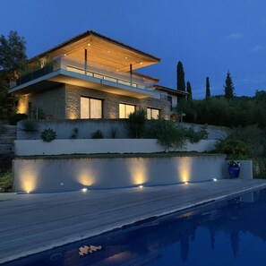 A modern house with a stone facade, large windows, and a swimming pool in the foreground. - 5* apartment in Villa prestige sea view swimming pool 17x4 exclusive Air conditioning  (Carqueiranne)