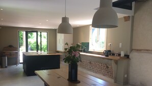Een moderne keuken met een houten aanrecht, een centraal eiland en hanglampen.
