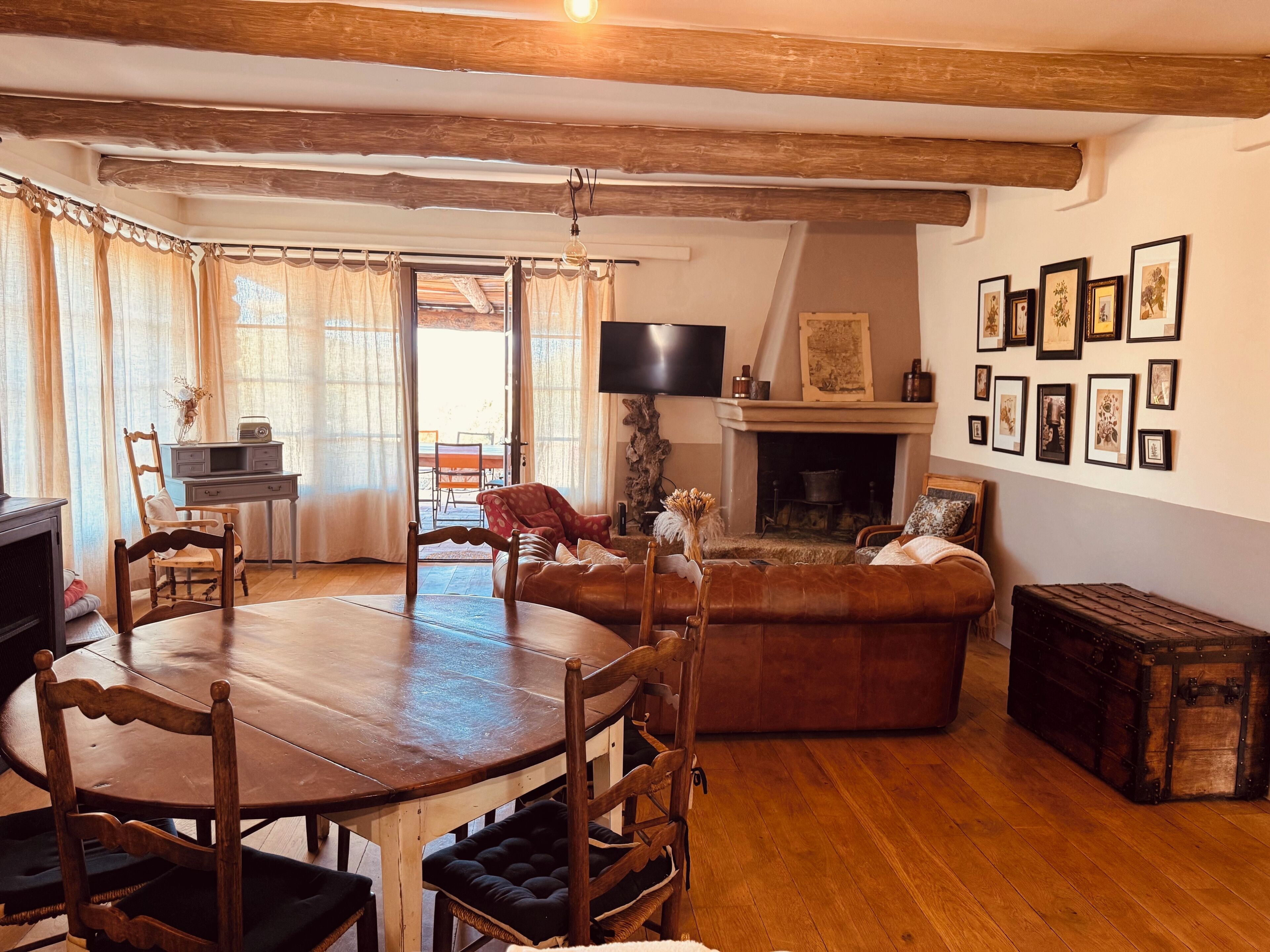 Un salon chaleureux avec une table à manger en bois, un canapé en cuir et une cheminée.