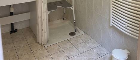 Une salle de bain équipée d’une douche, d’un lavabo, de toilettes et d’un porte-serviettes.