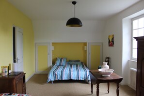 A bedroom with a bed, a table with a bowl, and a hanging light fixture. - Villa 6-10 pers in Espalion in Aveyron, at the gateway to Aubrac (Espalion)