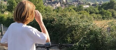 Una persona en bicicleta con vistas a un pueblo y una iglesia al fondo.