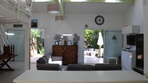 A spacious living room with a high ceiling, skylights, a large sofa, a wooden cabinet, and a television. - Bright house at 50m sea with garden without opposite (Bouzigues)