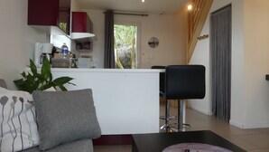 A modern living room with a sofa, a coffee table, and a remote control. - COTTAGE IDEALLY LOCATED (Saint-Évarzec)