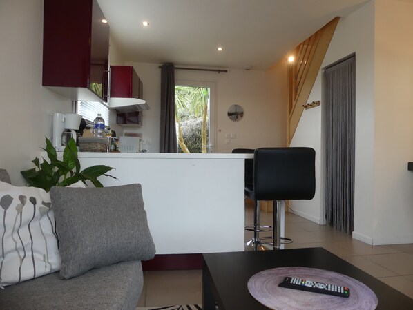 Un salon moderne avec un canapé, une table basse et une télécommande.