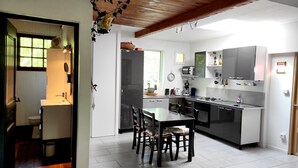 Una cocina moderna con comedor, que incluye una isla grande, electrodomésticos integrados y vistas al exterior.